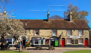 a large brick building with tables in front of it at The George and Dragon Inn in Long Melford