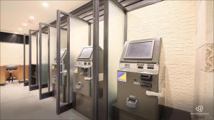 an atm machine in an office with its doors open at Daiwa Roynet Hotel Kobe Sannomiya in Kobe