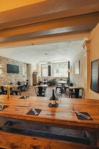 a large wooden table in a room with tables and chairs at LE PATIO in Grignan