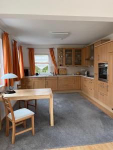 a kitchen with wooden cabinets and a wooden table at Haus Ammertal in Peißenberg