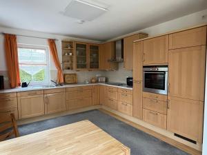 a kitchen with wooden cabinets and a table in it at Haus Ammertal in Peißenberg