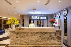 a woman standing behind a reception desk in a hotel lobby at Ruby Luxury Hotel in Nha Trang +155 photos
