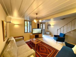 a living room with a couch and a tv at The Prοfessοrs House - Myrina 1922 in Myrina