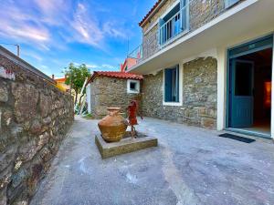a large vase sitting next to a stone building at The Prοfessοrs House - Myrina 1922 in Myrina