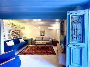 a blue living room with a couch and a table at The Prοfessοrs House - Myrina 1922 in Myrina