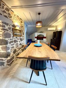 a wooden table in a room with a stone wall at The Prοfessοrs House - Myrina 1922 in Myrina