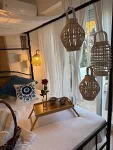 a bedroom with a bed with a table and chandeliers at Hara's House 1 in Gerakini +14 photos