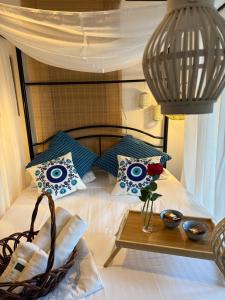 a bed with blue and white pillows and a table at Hara's House 1 in Gerakini