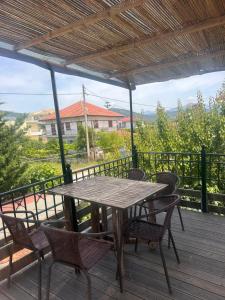 a wooden table and chairs on a deck at Bochtis Acrogiali in Ammoudia