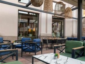 a restaurant with blue chairs and tables and windows at RELAX-zepter in Vrnjačka Banja