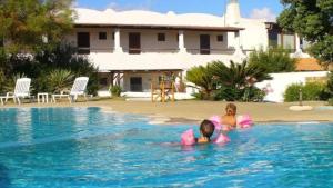 two people in the water in a swimming pool at Villetta Darsena con piscina gratuita dal 18 Luglio al 30 Agosto in Vulcano +5 photos