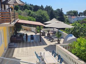 a patio with tables and chairs and umbrellas at Apartments Suha Punta - Villa Babalonija in Kampor