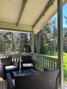 a screened in porch with chairs and a table at Hummelviks stugan in Eckerö +3 photos