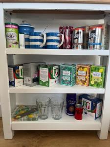 a cabinet filled with lots of food and drinks at Trethvor House FREE PARKING, Ensuite Double Quiet residential area in Padstow