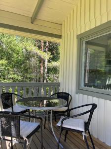 a patio with chairs and a table on a porch at Hummelviks stugan in Eckerö