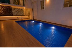 a swimming pool with lights in a house at Hotel H F at Assagao North Goa in Assagao +6 photos