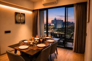 a dining room with a table and a large window at The Vilton in Raipur