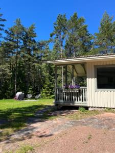 a house with a porch with flowers on it at Hummelviks stugan in Eckerö