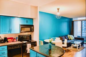 a kitchen with blue cabinets and a living room at Urban Nest in Toronto