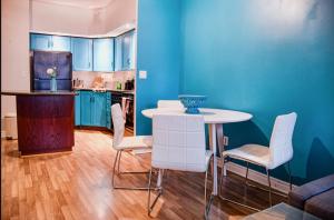 a kitchen with a table and chairs and blue walls at Urban Nest in Toronto