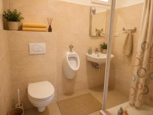 a bathroom with a toilet and a sink and a urinal at Apartament4you - Szczycionek in Korpele