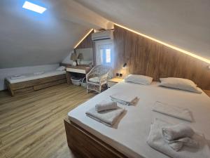 a bedroom with a large bed with towels on it at Nearby PORTONOVI-Norwegian-village DUPLEX in Đenovići +29 photos