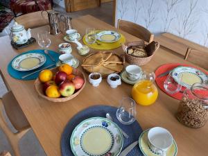 a table with plates and bowls of fruit on it at Ti Toenn et spa in Landéda