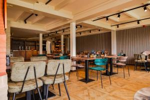 a restaurant with tables and chairs in a room at Hotel Restaurant Noordooster in Delfzijl +26 photos