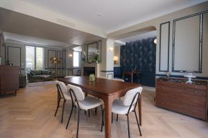 a kitchen and dining room with a wooden table and chairs at L'ODE A PIERRE - Chambres d'hôtes in Dax