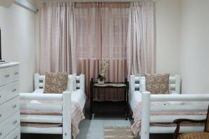 a bedroom with two white beds and a table at 12 On York Guesthouse in Bloemfontein +23 photos