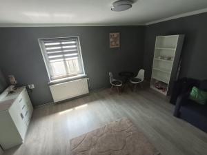 an empty living room with two chairs and a window at Ewula in Giżycko