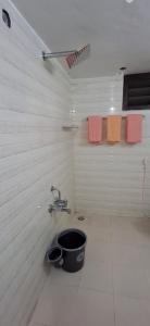 a bathroom with a bucket in the corner of a room at Umbrella Guest House - Palace Suite in Madurai +15 photos