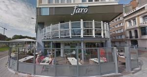 a restaurant with tables and chairs in front of a building at B&B Mercator in Ostend