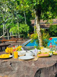 a table with food and drinks next to a pool at Eco Lux Villas in Ahangama