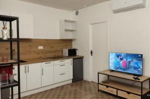 a kitchen with white cabinets and a tv on a table at T2 dans le centre historique de Manosque in Manosque