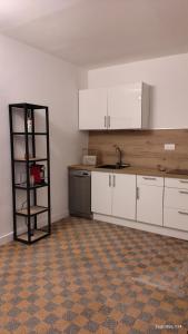 an empty kitchen with white cabinets and a sink at T2 dans le centre historique de Manosque in Manosque