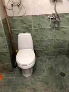 a bathroom with a white toilet and a shower at Квартира in Ureki