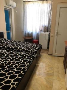 a bedroom with a black and white bed and a window at Квартира in Ureki