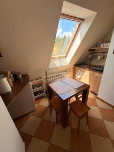 an attic kitchen with a table and a window at U Celiny - Widok na Tatry - Region Białki Tatrzańskiej in Rzepiska +20 photos