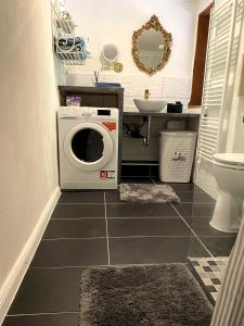 a bathroom with a washing machine in the floor at Charmante Ferienwohnung unter Reet in Windbergen +7 photos