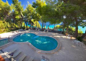 a swimming pool with chairs and a table and water at Evripidis Hotel Afitos in Afitos