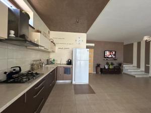 a kitchen with a refrigerator in the middle of it at Villa Life Family Sea House in Zatoka