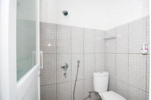 a bathroom with a toilet and a shower at RedDoorz Plus Syariah at Polamas Andalas in Padang +33 photos
