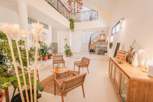 a living room with chairs and tables and plants at Casa Jardim di Sol in Praia