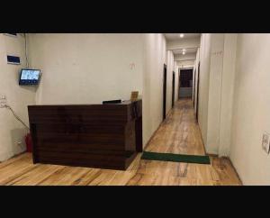a hallway with a wooden dresser in a room at Rajyog Resort in Dhule