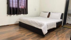a bed with white sheets and pillows in a room at Rajyog Resort in Dhule