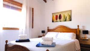 a bedroom with a bed with two towels on it at El Rafalet in Jávea +28 photos