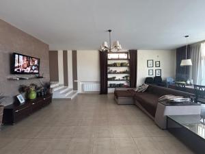 a living room with a couch and a tv at Villa Life Family Sea House in Zatoka