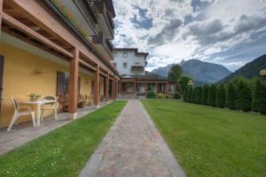 a house with a lawn with a table and chairs at Hotel Panoramic in Auronzo di Cadore +154 photos