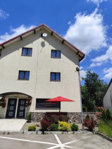 a large building with a red umbrella in front of it at Apartament lângă Catedrală in Câmpulung Moldovenesc